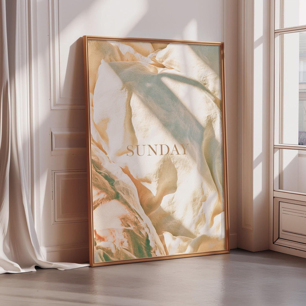 A large framed poster with a textured, abstract design is displayed on a wall in a room with sunlight streaming in from a window.