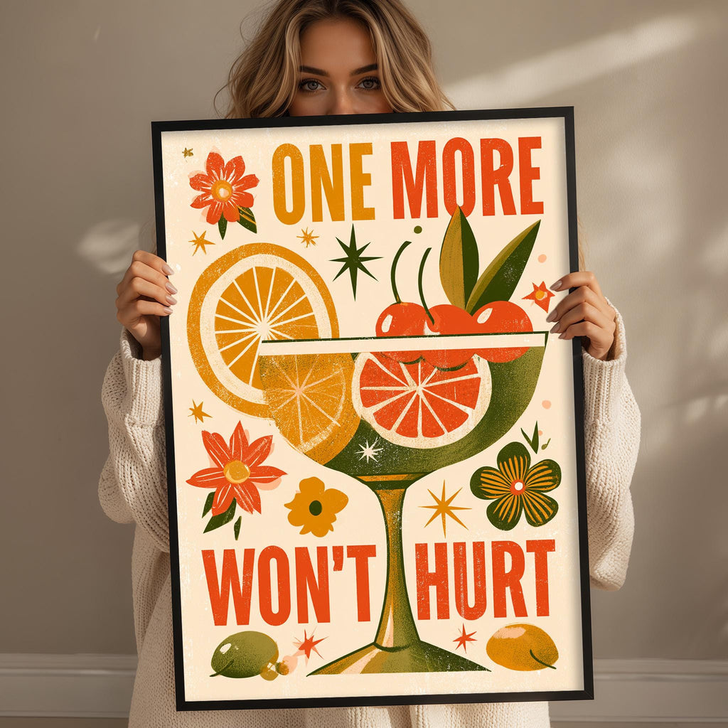 A woman is holding up a framed poster with a colorful design featuring various fruits and flowers, along with the text "One more won't hurt".