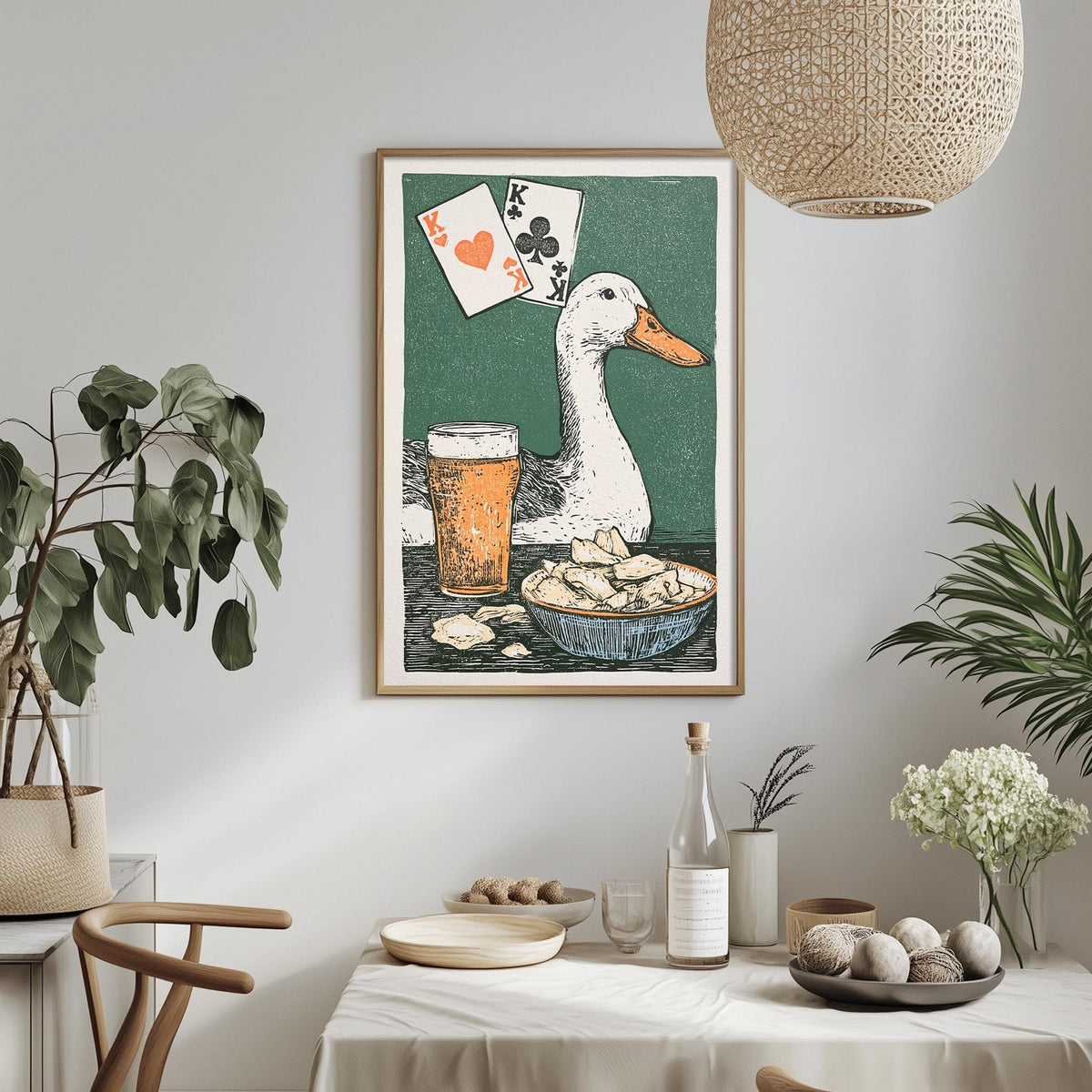 a framed illustration of a duck with playing cards above a table with food and drinks, including a beer glass and a bowl of chips.