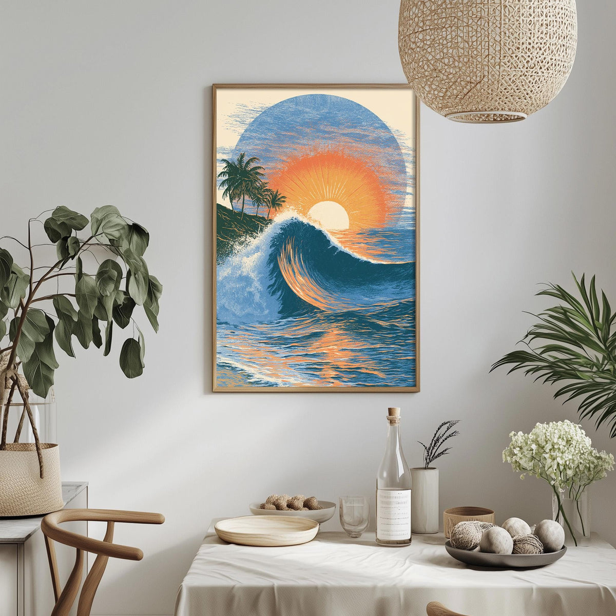 a framed painting of a sunset over the ocean, with palm trees and a crashing wave in the foreground. The painting is hung on a wall above a dining table, which has a vase of flowers, a bottle of wine, and a bowl of fruit on it.