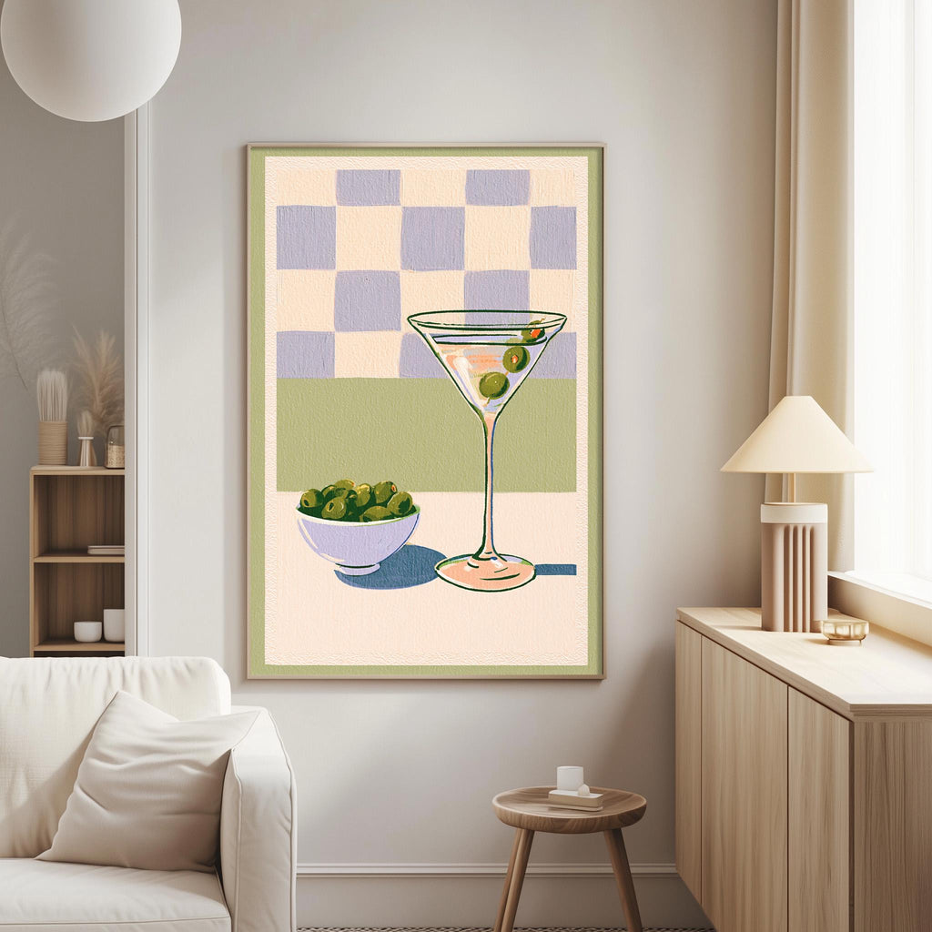 a living room with a white couch, a wooden side table, and a framed illustration of a martini glass with olives on the wall.