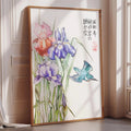 A framed painting depicting a vibrant illustration of colorful flowers, including purple irises and a blue bird, is displayed on a wall in a room with sunlight streaming in through a window.