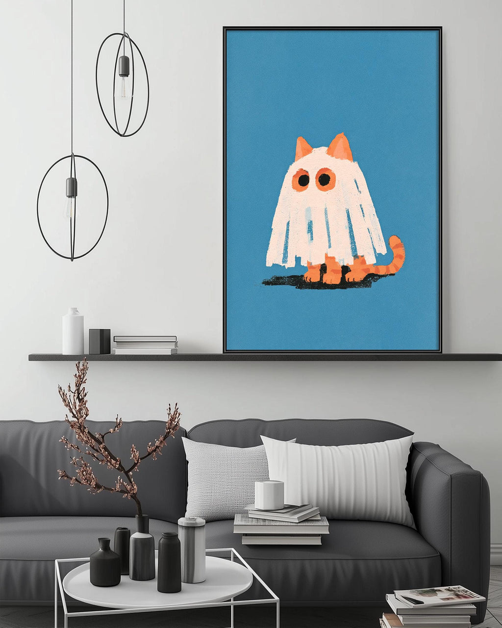 a cozy living room with a gray couch, a coffee table, and a large framed picture of a ghost cat on the wall.