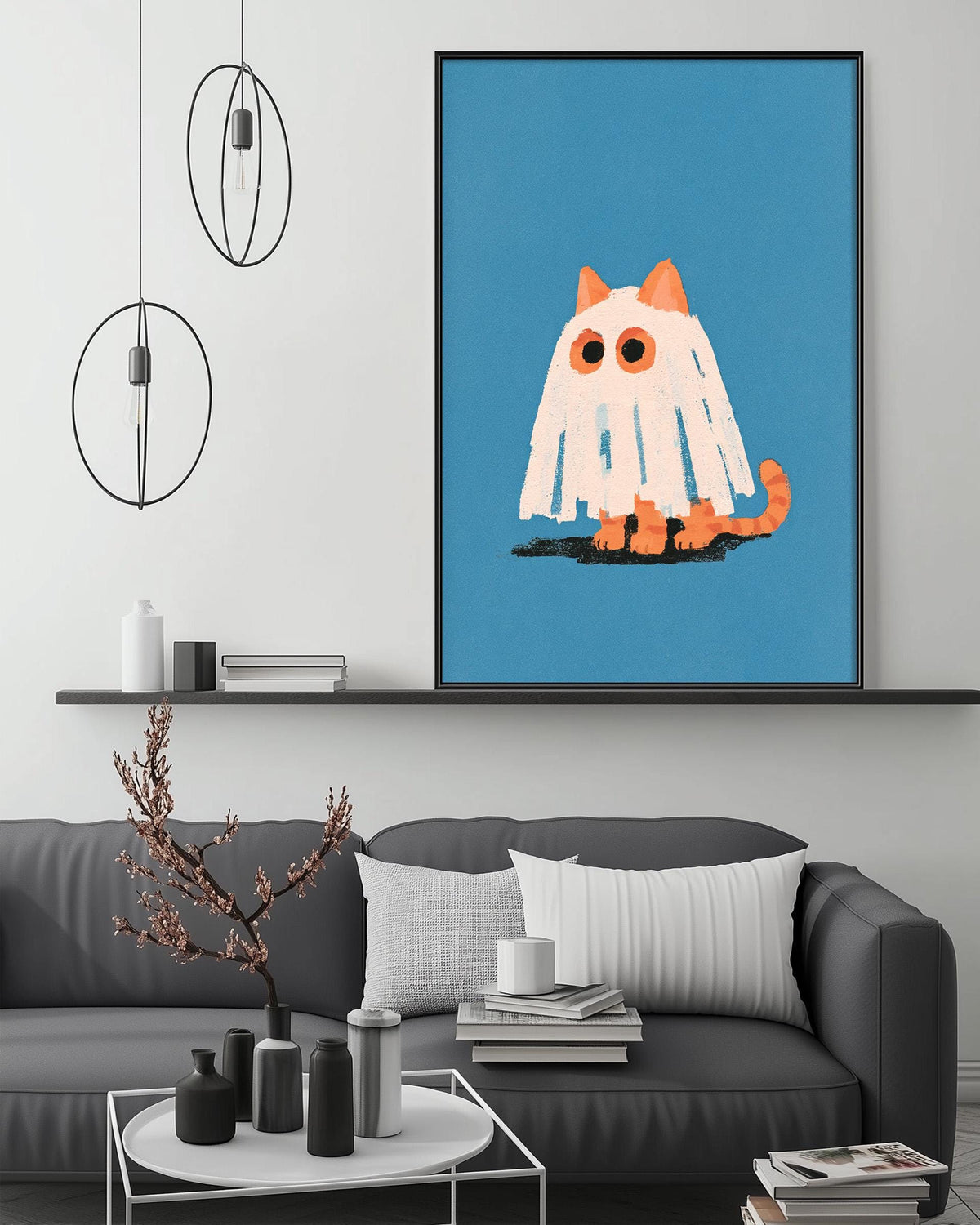 a cozy living room with a gray couch, a coffee table, and a large framed picture of a ghost cat on the wall.