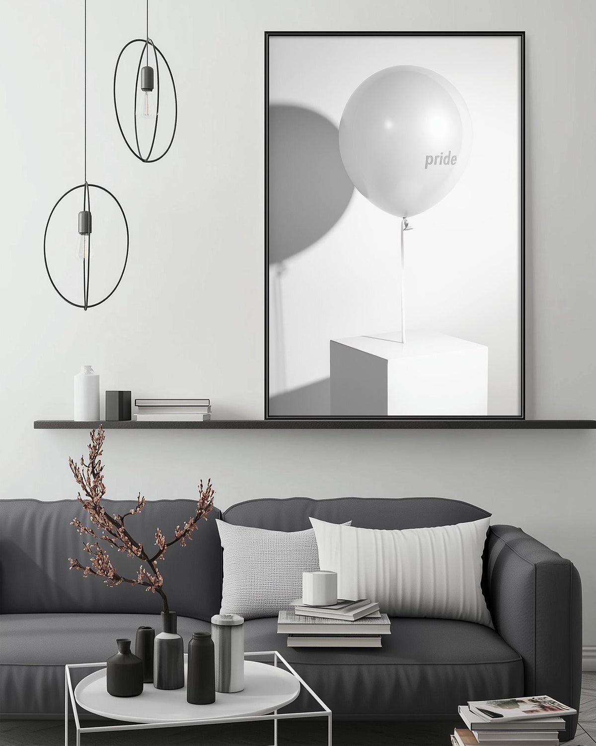 a modern living room with a gray sofa, a coffee table, and a large framed picture of a white balloon with the word "pride" on it. The room has a minimalist and clean design, with a black and white color scheme.