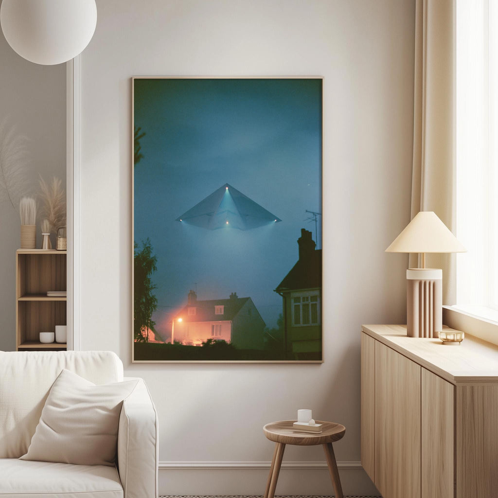 a large framed artwork hanging on a wall in a living room, featuring a silhouetted building and a flying object against a dark sky.