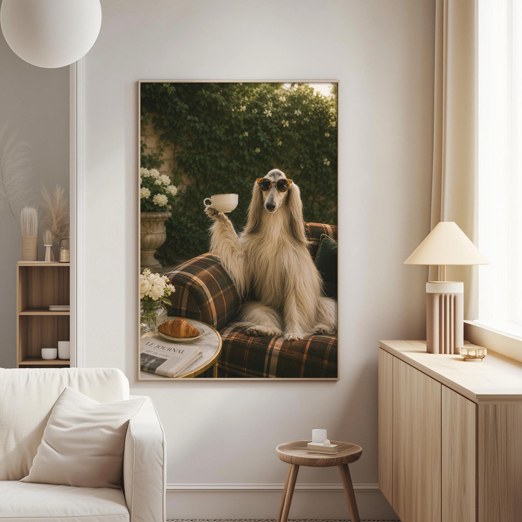 A large framed photograph of a dog sitting on a plaid couch, holding a cup and surrounded by flowers and a newspaper, is displayed on the wall in a cozy living room setting.