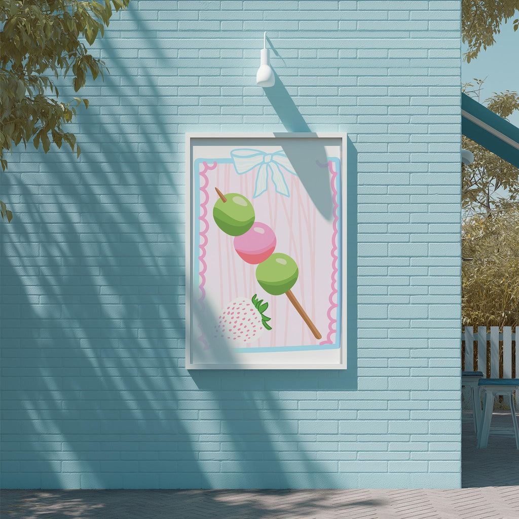 A framed illustration of a strawberry on a stick is displayed on a blue brick wall, with a white light fixture above it.
