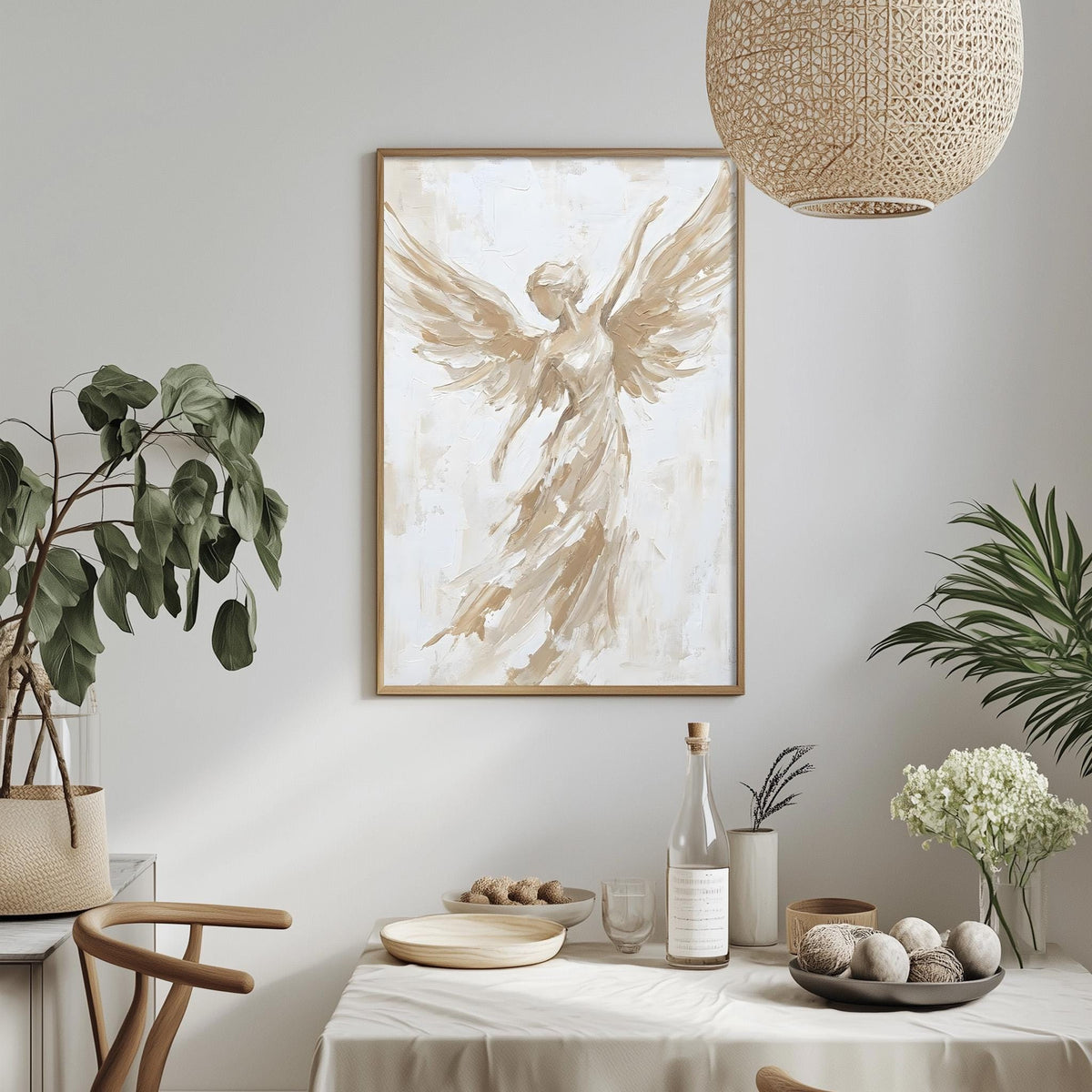 a dining table with a white tablecloth, a bowl of fruit, a bottle, and a vase with flowers. Above the table, there is a framed painting of an angel with outstretched wings.