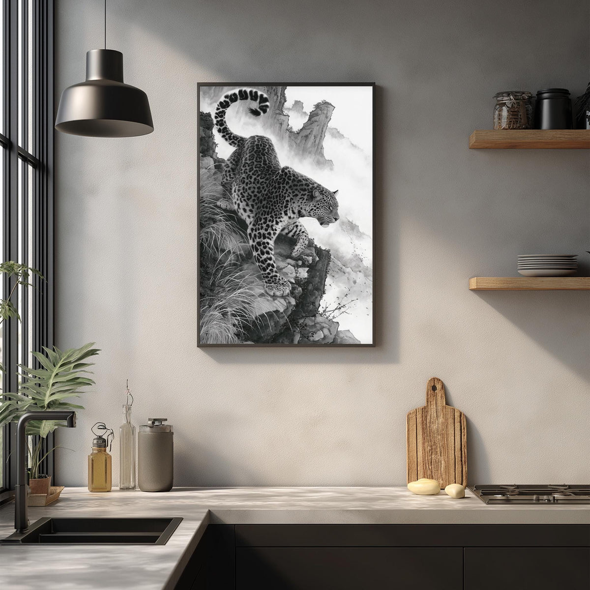 a framed black and white photograph of a leopard on a rocky cliff, hanging on a wall above a kitchen counter.