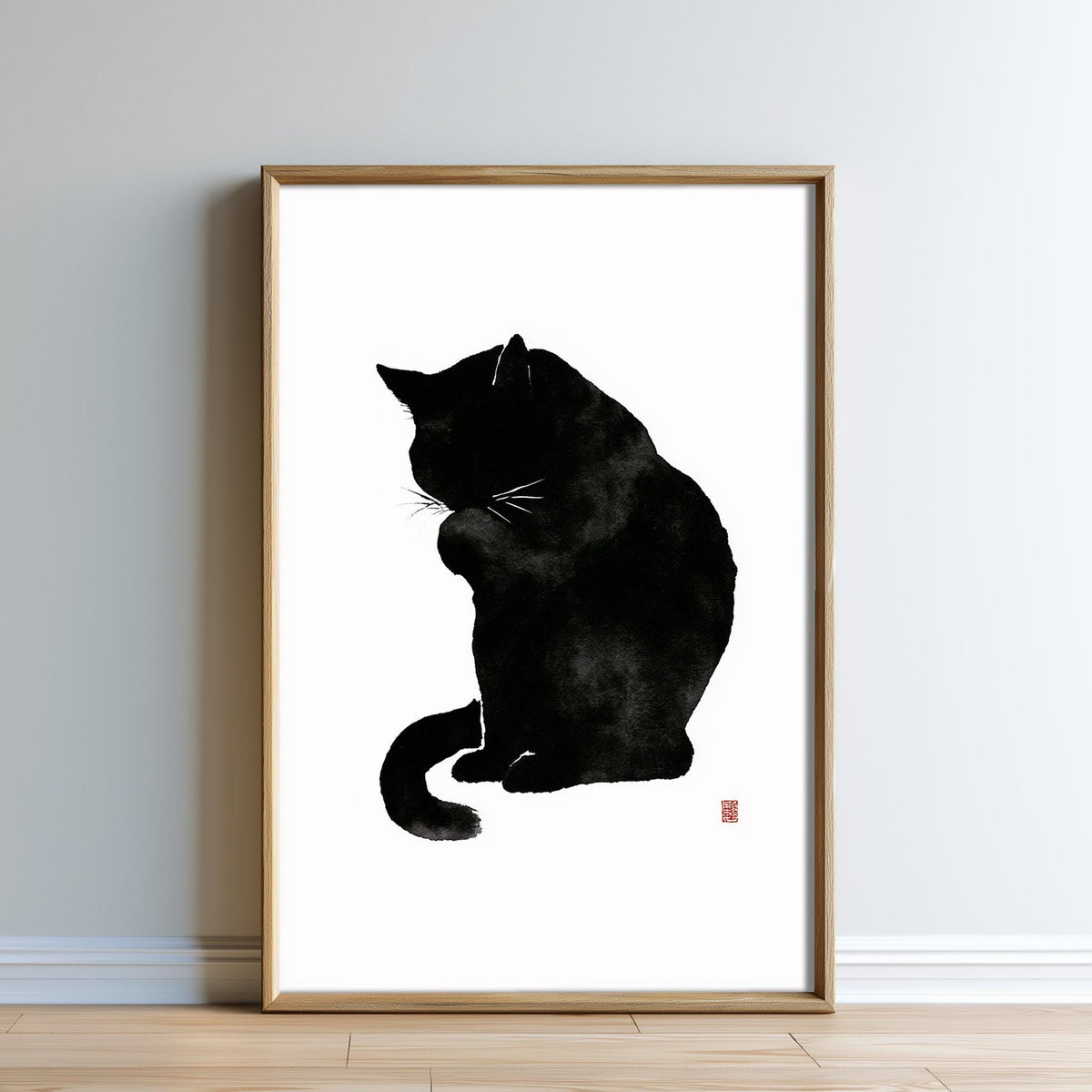 A framed black and white illustration of a cat sitting on a surface.