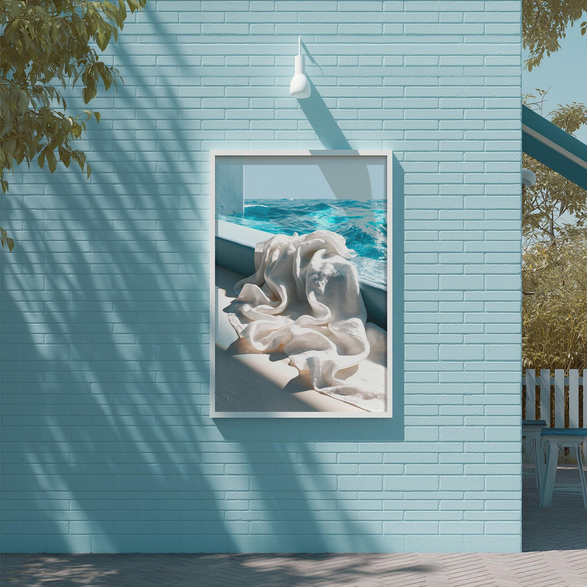a blue wall with a framed picture of a white cloth hanging on it, depicting a serene scene of a body of water with a person lying on the ground.