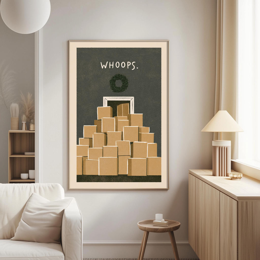 a living room with a framed poster of a stack of brown boxes on the wall, a white couch, a small table, and a lamp.