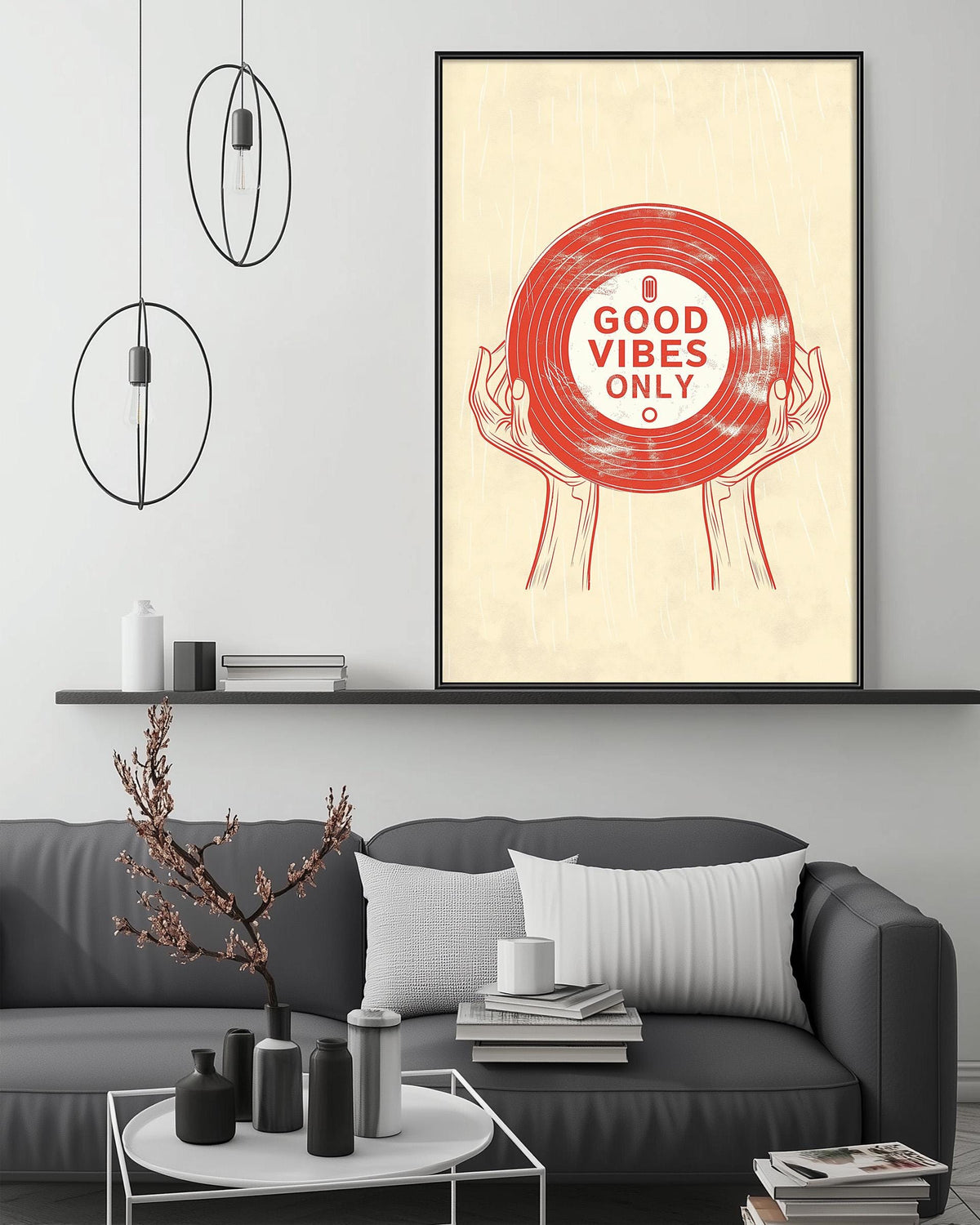 a living room with a gray couch, a coffee table, and a framed poster on the wall. The poster has a red vinyl record and the text "A GOOD VIBES ONLY" written on it.