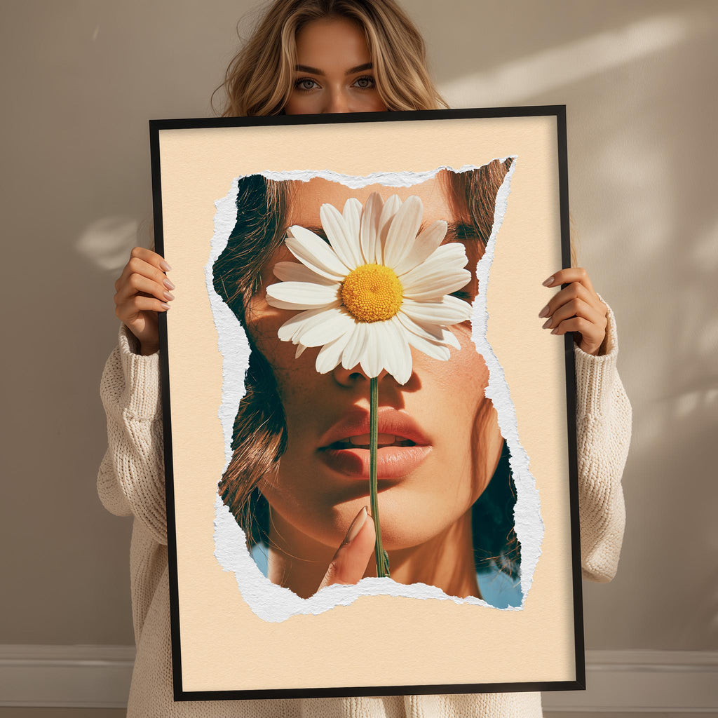 A woman holding a framed picture of a woman's face partially obscured by a large white flower.