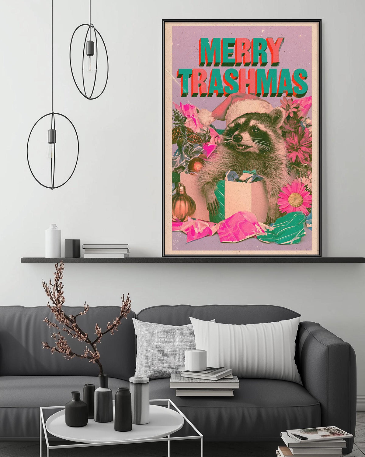 a large framed poster with a raccoon wearing a Santa hat and surrounded by Christmas decorations, including a gift box and flowers, on a wall above a gray couch and a coffee table.