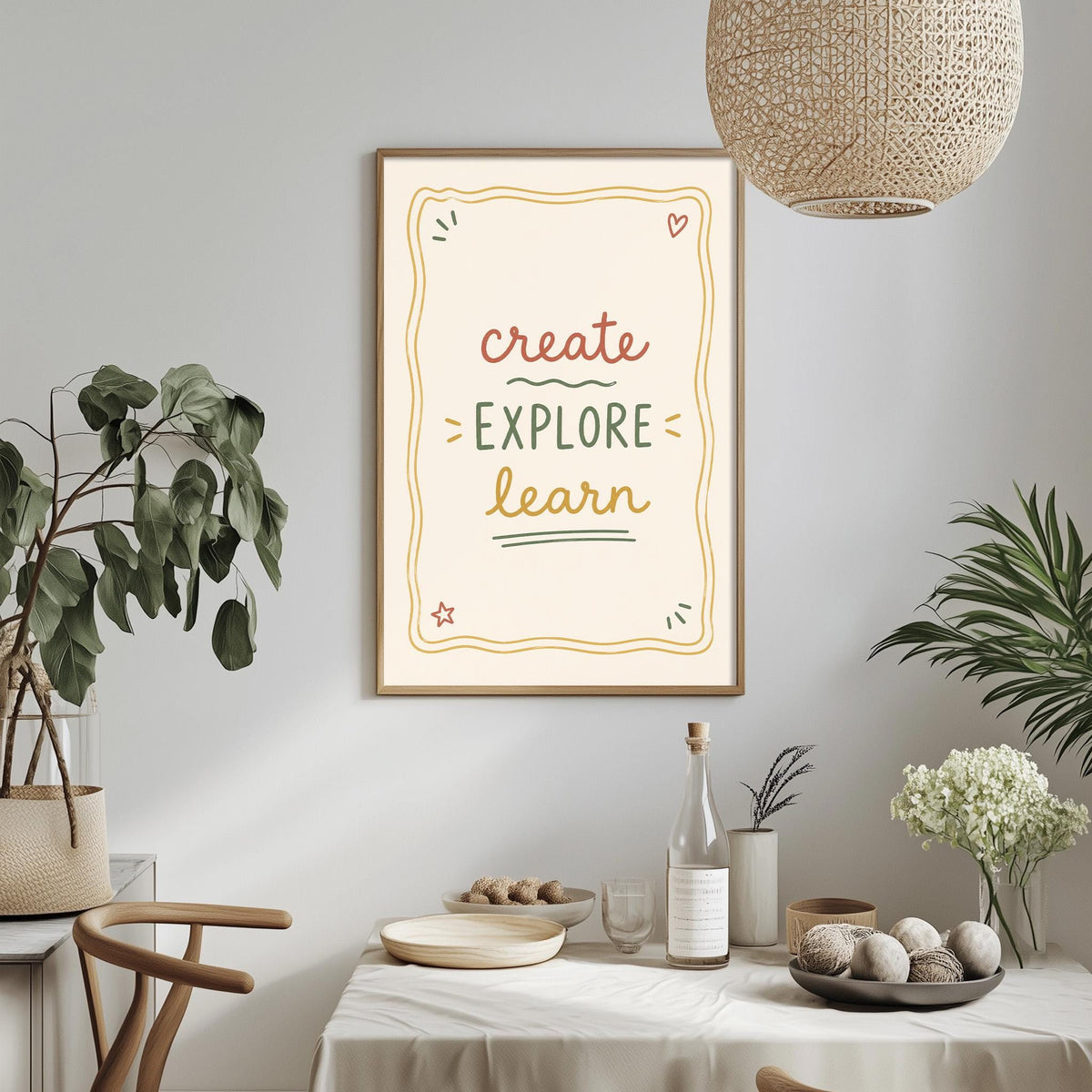 a framed poster with the text "CREATE EXPLORE LEARN" hanging on a wall above a dining table with various items on it, including a bottle, a bowl, and a vase.