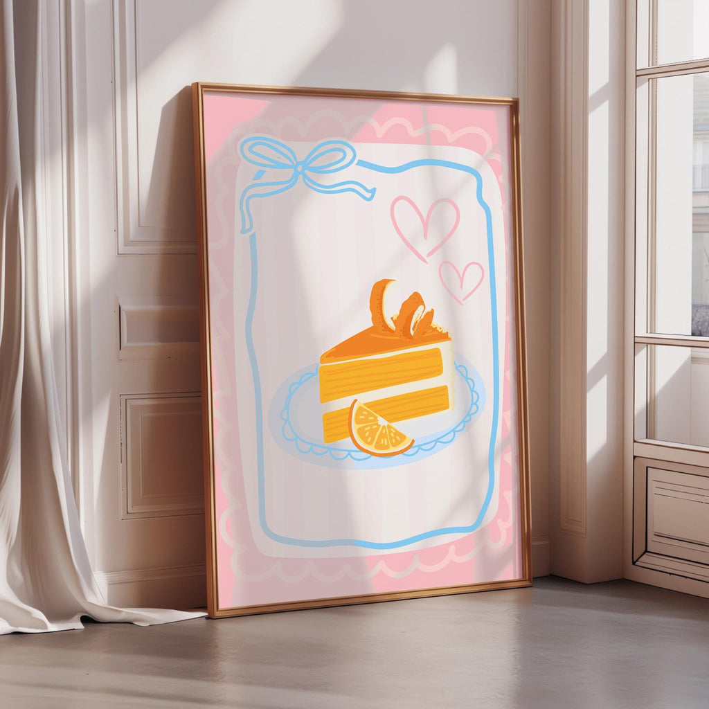 A framed illustration of a slice of cake with a heart and an orange slice on a pink background.