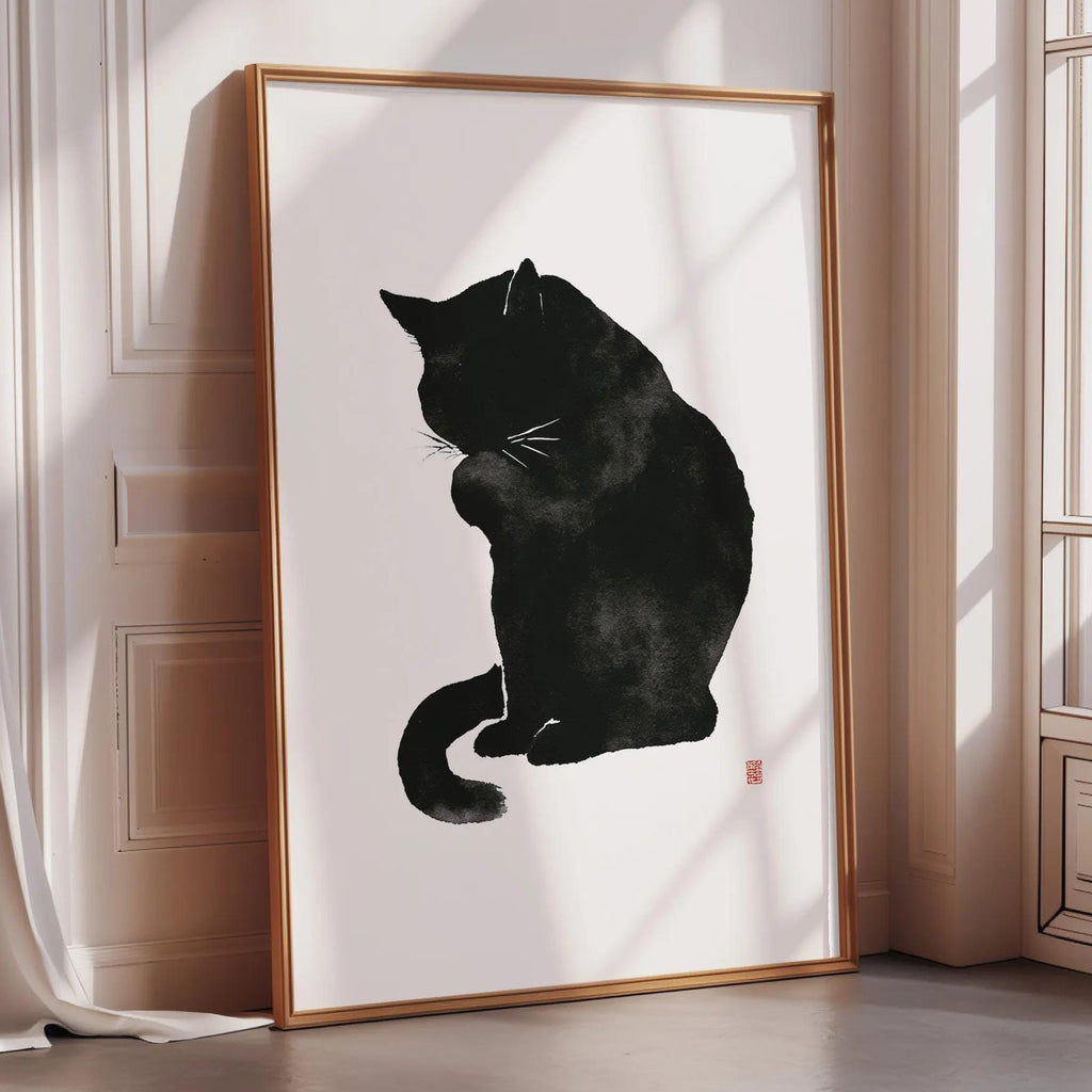 A framed black and white illustration of a cat sitting on a white surface.