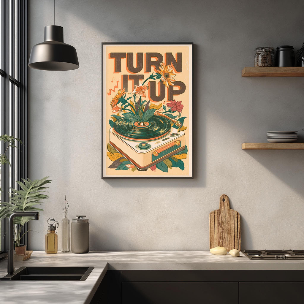 a framed poster with the text "TURN IT UP" hanging on a wall above a kitchen counter.