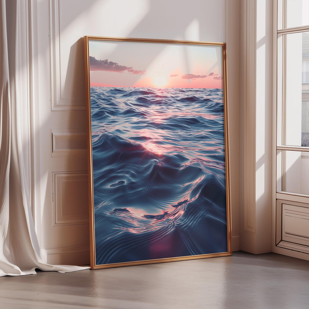 a large, framed picture of a serene ocean scene with waves gently lapping against the shore. The sky above the ocean is a beautiful gradient of pink and orange, creating a stunning backdrop for the tranquil scene. The picture is displayed on a wall, and there is a window nearby, allowing natural light to illuminate the artwork.