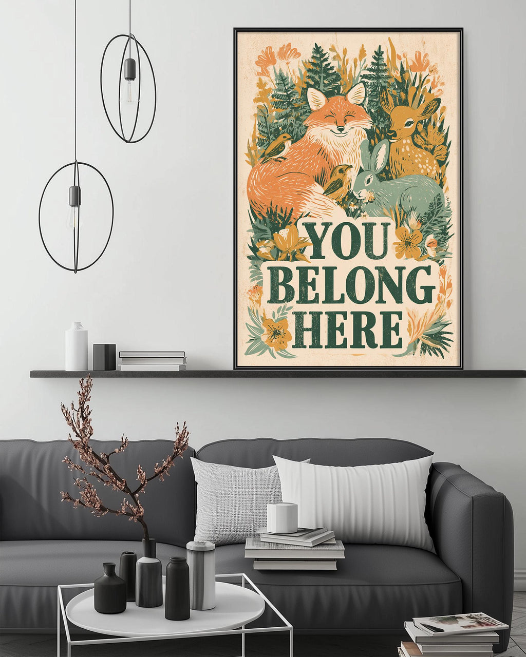 a cozy living room with a gray couch, a coffee table, and a framed poster with a whimsical illustration of animals and the text "YOU BELONG HERE".
