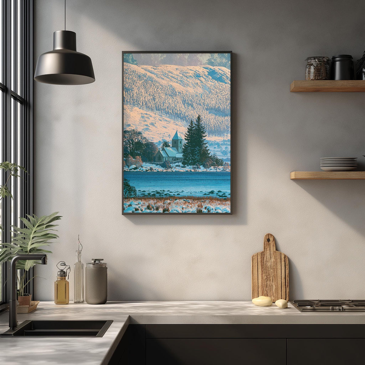 a kitchen counter with a framed picture of a snowy mountain landscape hanging above it. The kitchen counter also has various kitchen items such as a cutting board, a bottle, and a vase.
