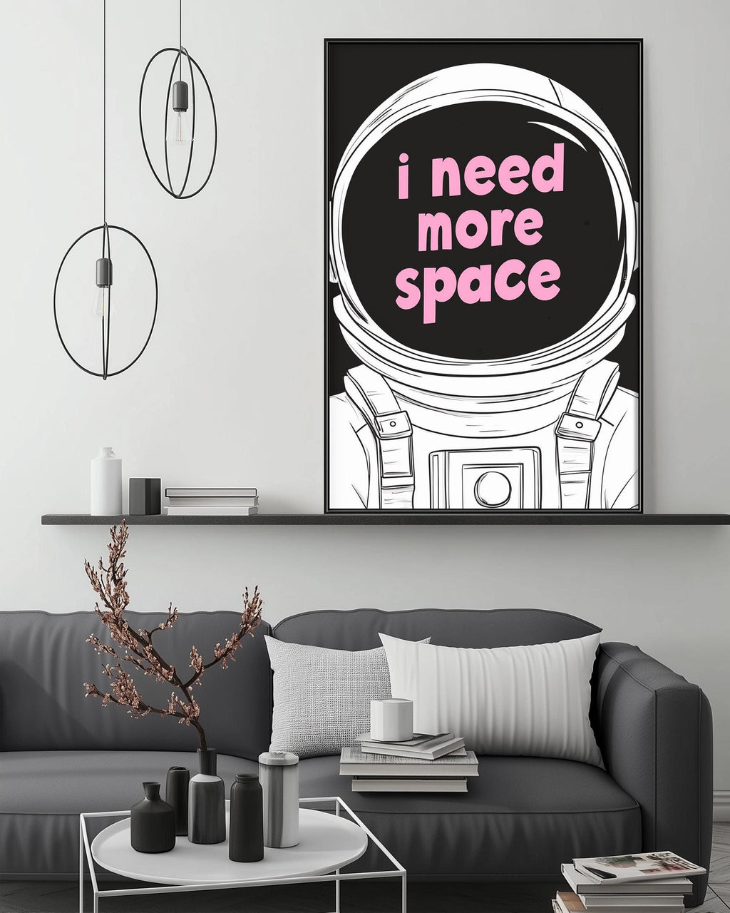a modern living room with a gray sofa, a coffee table, and a large framed poster of an astronaut's helmet with the text "I need more space" displayed on it.