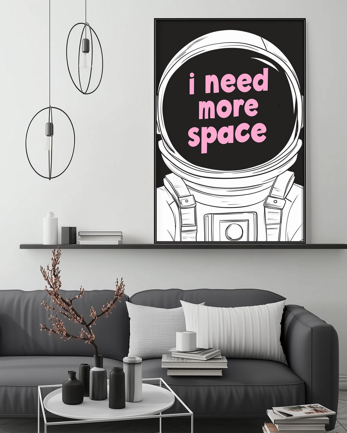a modern living room with a gray sofa, a coffee table, and a large framed poster of an astronaut's helmet with the text "I need more space" displayed on it.