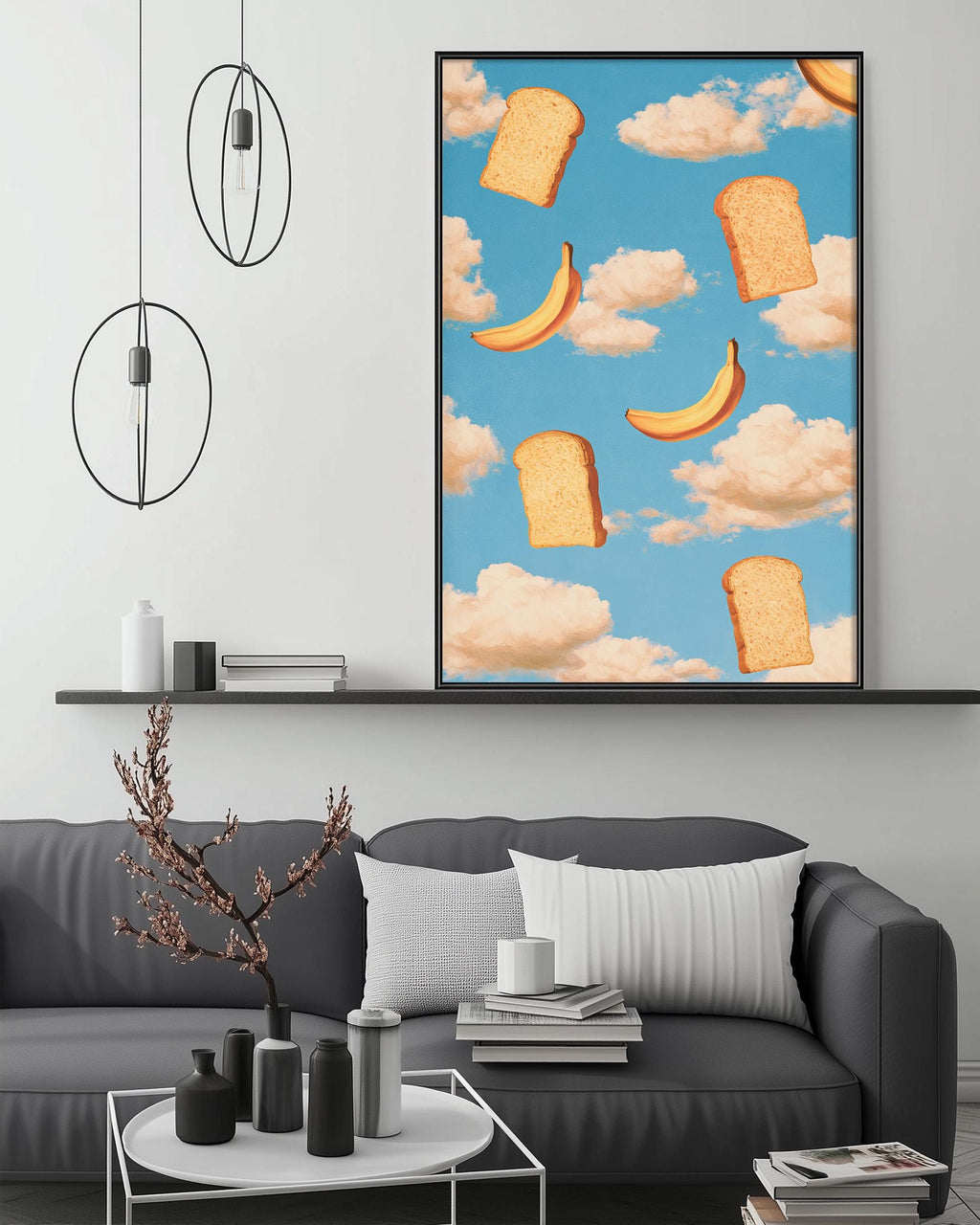 a modern living room with a gray sofa, a coffee table, and a large framed artwork depicting bananas and bread floating in the sky.