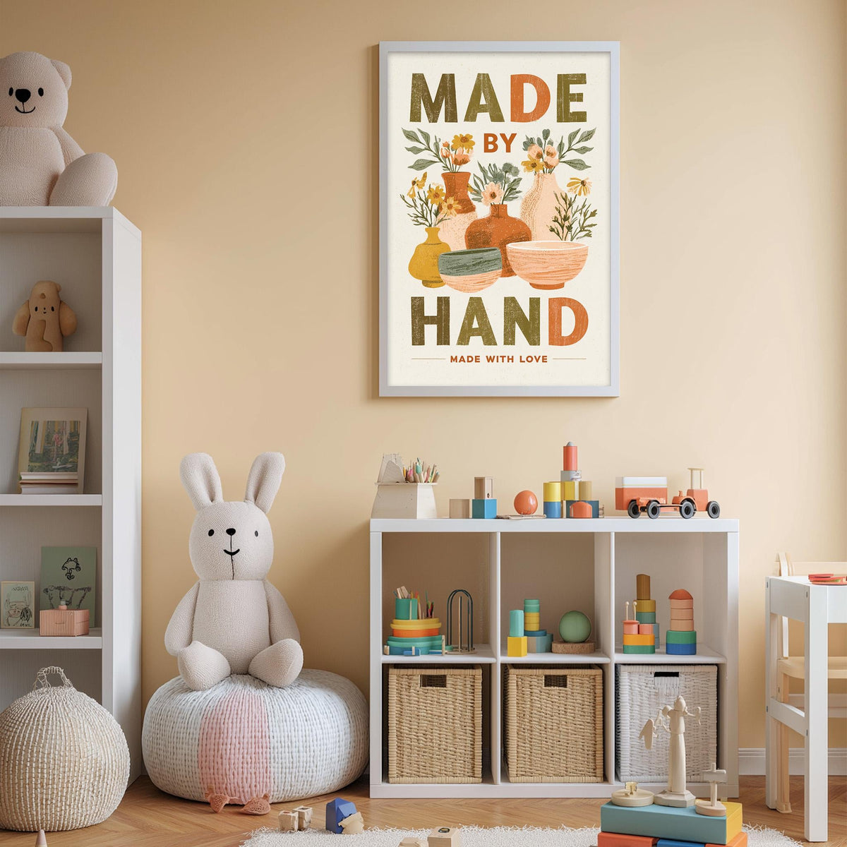 A child's bedroom with a white bookshelf, a stuffed rabbit, and a toy train set. Above the bookshelf is a framed poster with the text "MADE BY HAND MADE WITH LOVE".