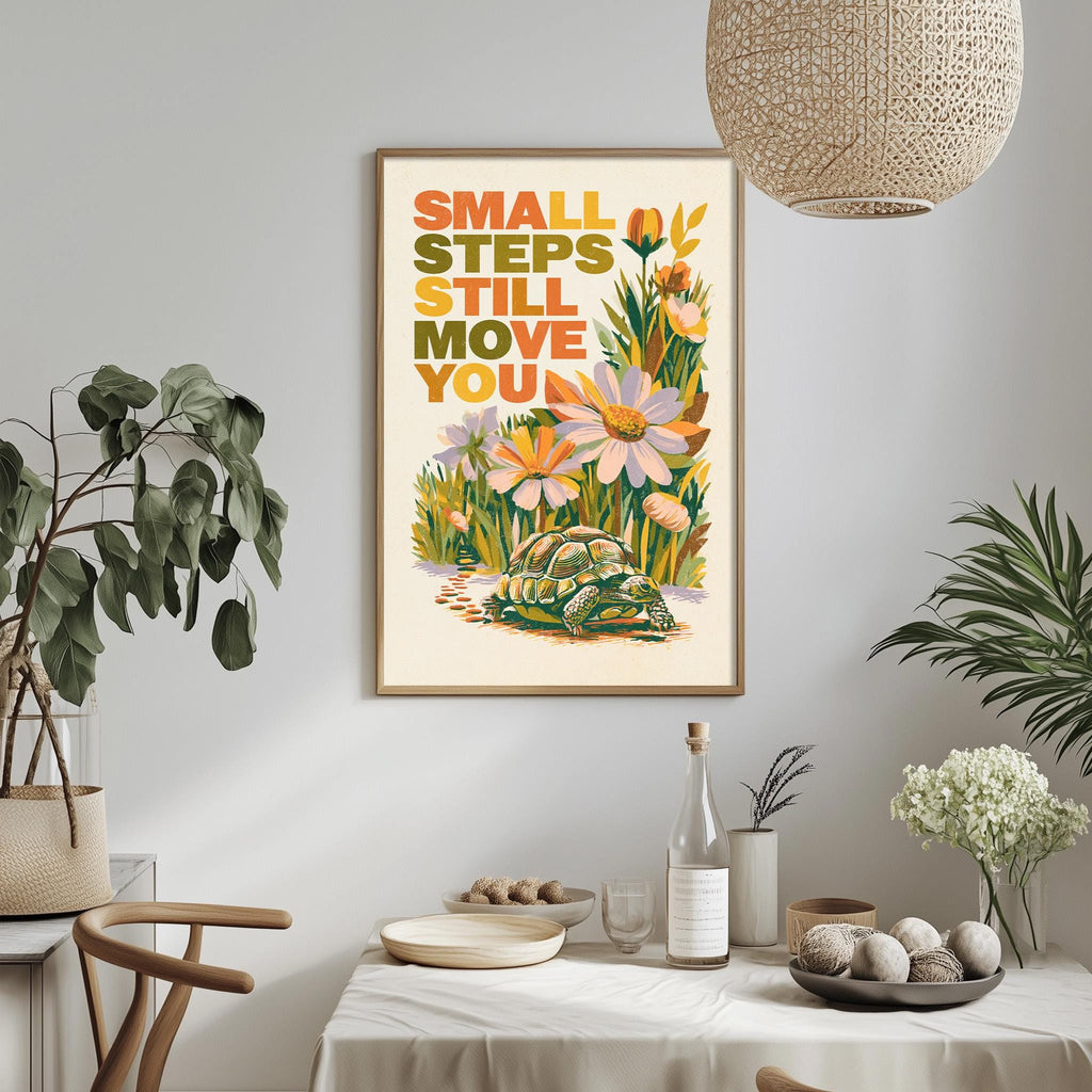 a framed poster with a turtle and flowers hanging on a wall above a table with various items on it.
