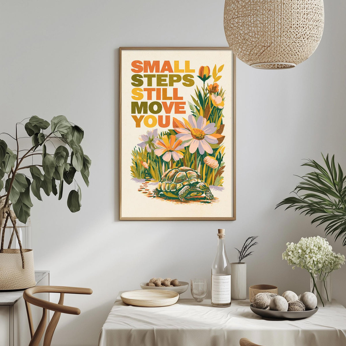 a framed poster with a turtle and flowers hanging on a wall above a table with various items on it.