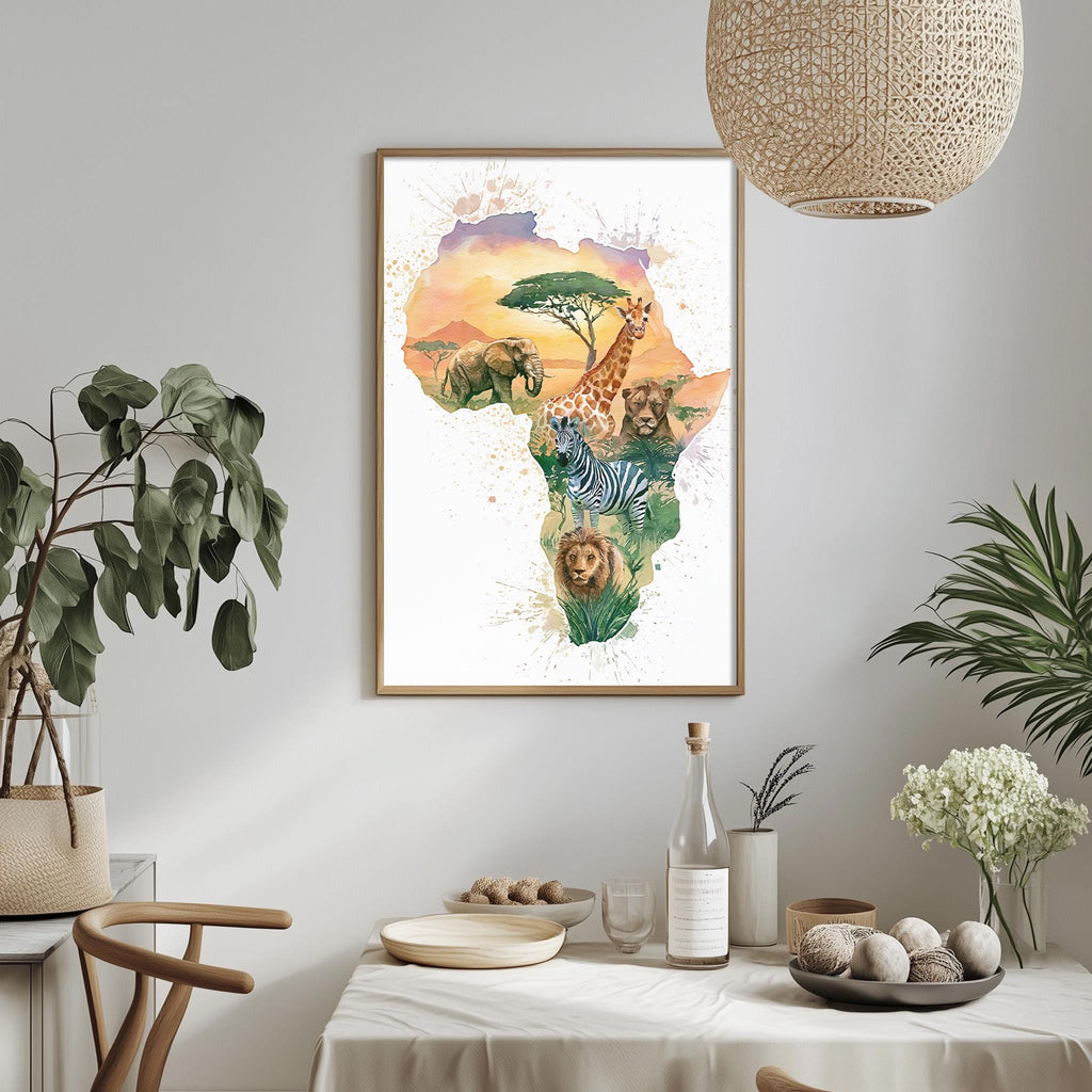 a framed watercolor painting of an African continent with various animals, including elephants, giraffes, zebras, and lions, set against a colorful sky. The painting is hung on a wall above a dining table with a vase of flowers, a bottle, and a bowl of fruit.