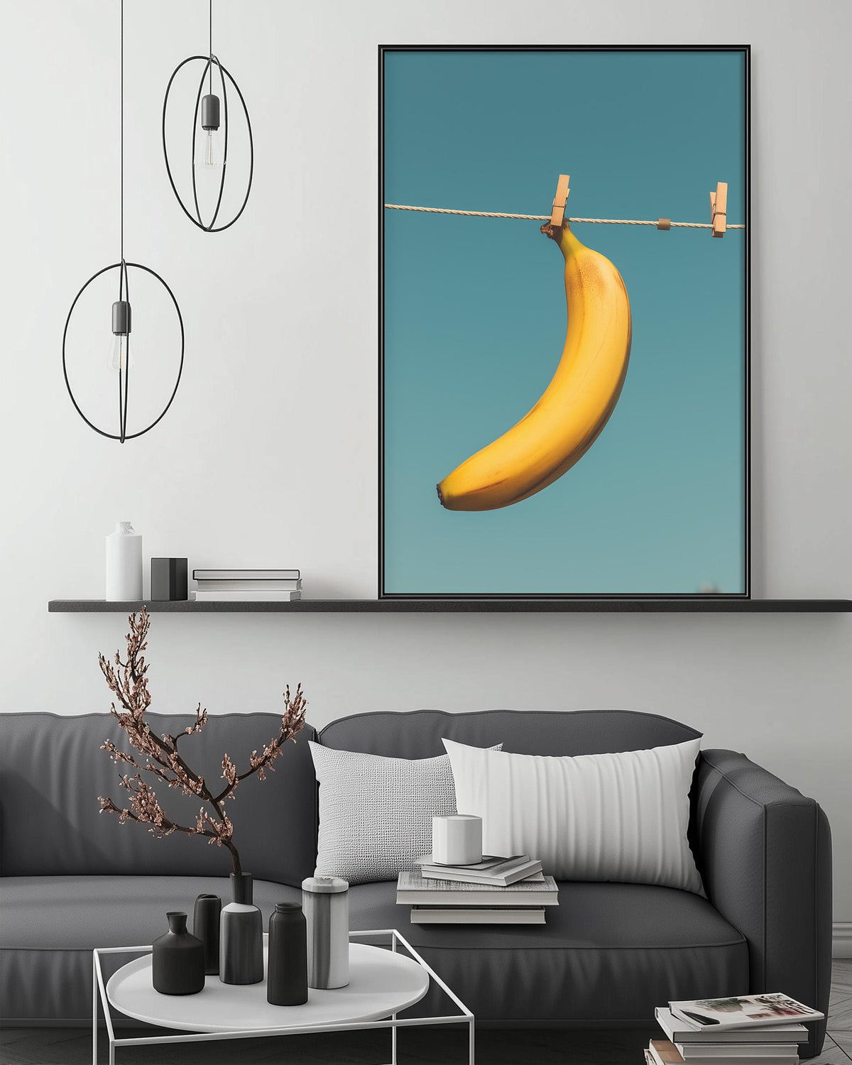 a large framed picture of a banana hanging from a clothesline, with a minimalist and modern living room setting in the background.