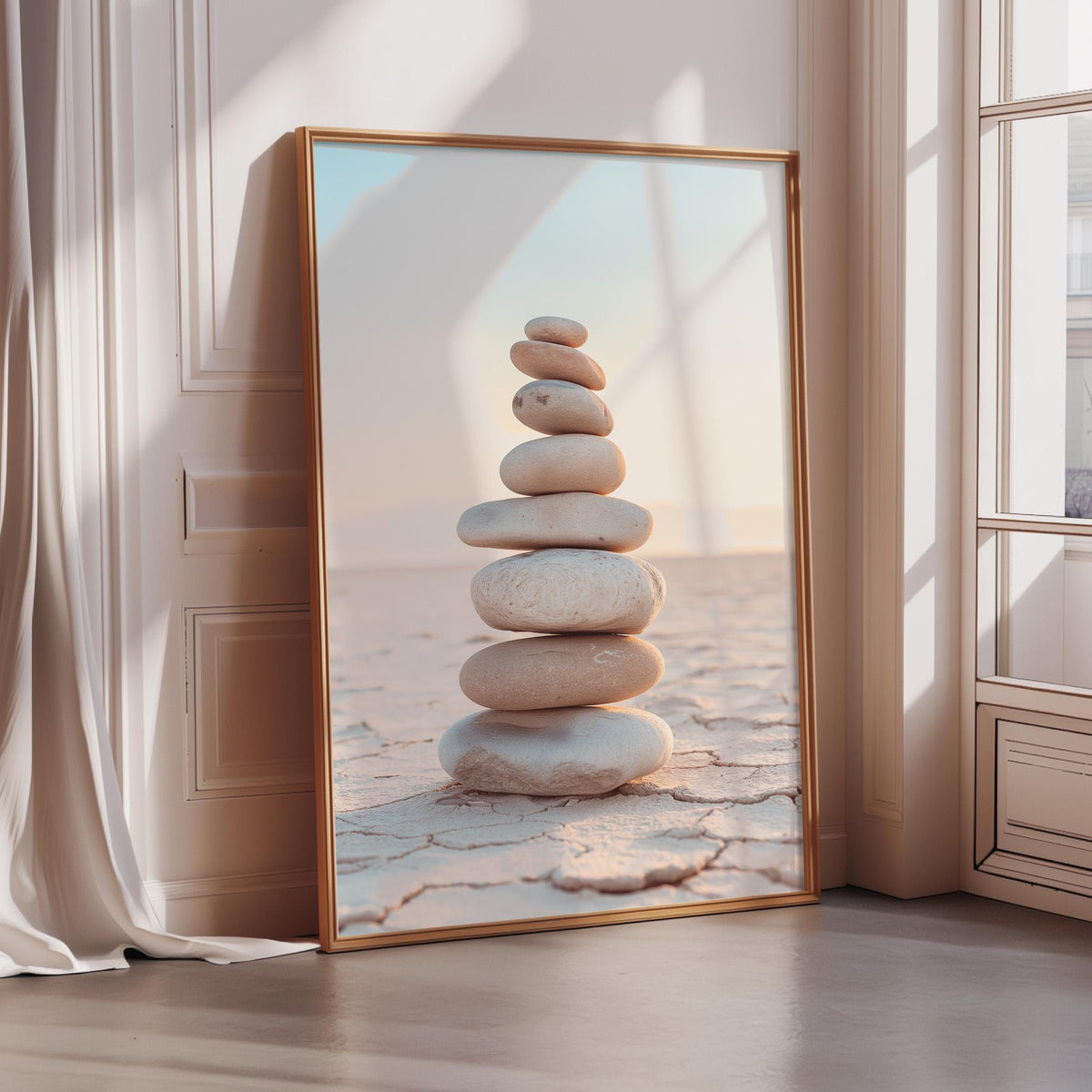 A large framed photograph of a stack of stones is displayed on a wall, with a window and curtains visible in the background.