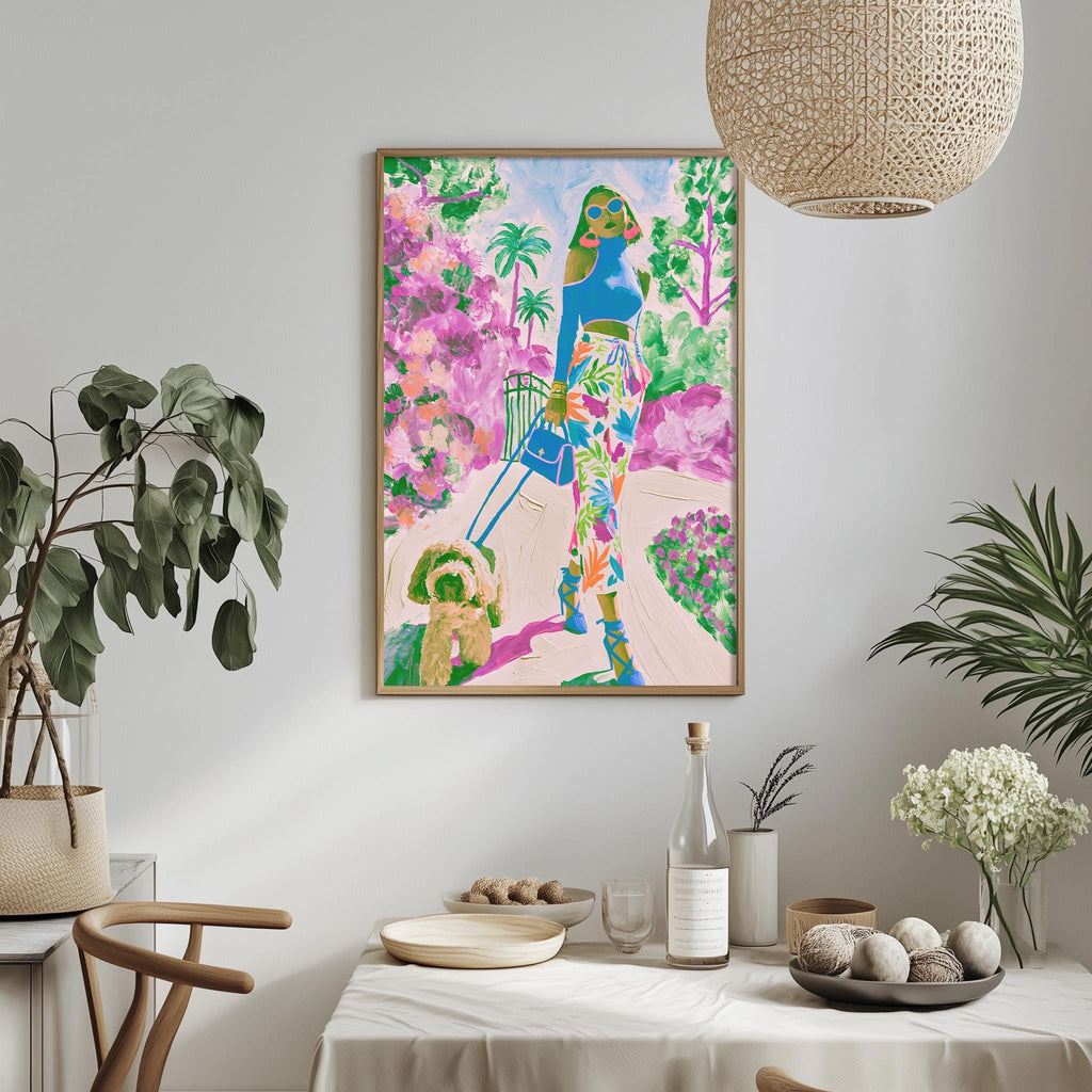 a vibrant and colorful painting of a woman walking with a dog in a tropical garden setting, hanging on a wall above a dining table with various decorative items and plants.