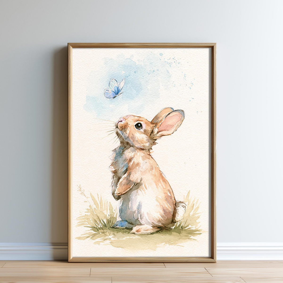A framed watercolor painting depicting a rabbit sitting in the grass, looking up at a blue butterfly in the air.