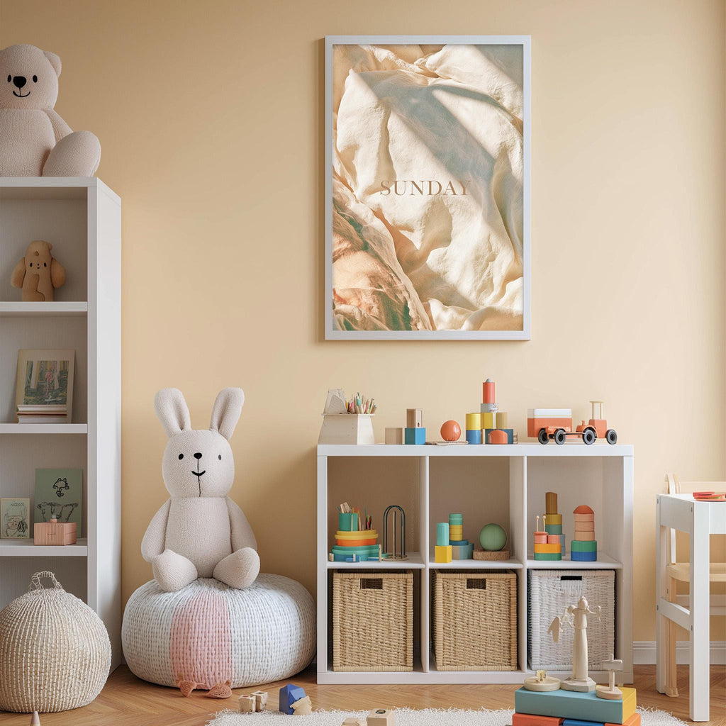 A cozy and well-organized children's playroom with a variety of toys and storage solutions. The room has a warm, inviting atmosphere with a beige color scheme. A large poster with the word "SUNDAY" is displayed on the wall, adding a playful touch to the space.