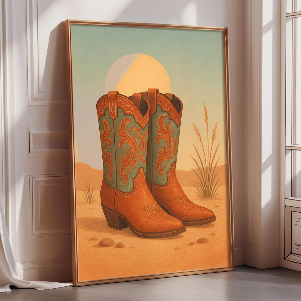 A framed painting of a pair of cowboy boots in a desert landscape, with a large sun in the background.