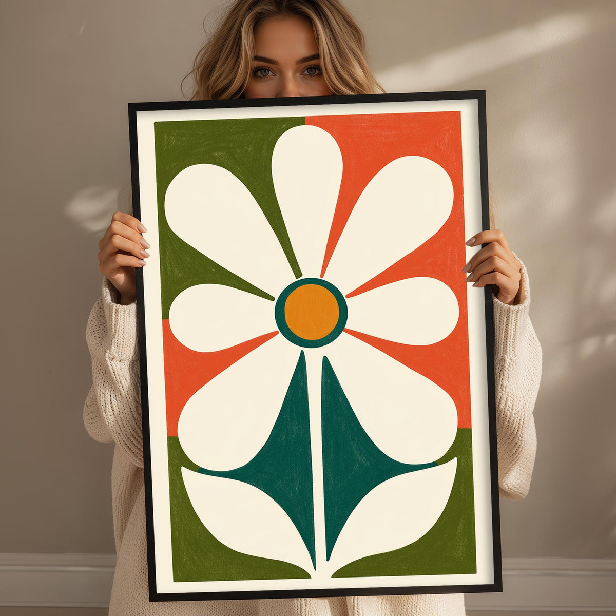 A woman is holding up a large framed print of a colorful abstract flower design.