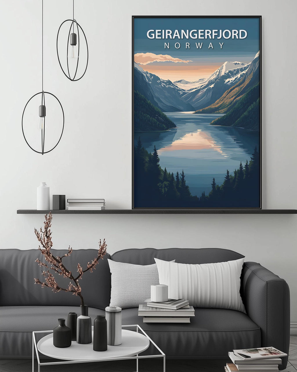 a large framed poster of a scenic mountain landscape with a lake, hanging on a wall above a gray couch with a coffee table in front of it.