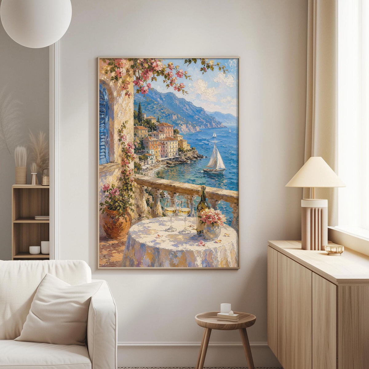 a large painting of a picturesque coastal town with a balcony overlooking the sea, a sailboat, and a table set with flowers and wine glasses.