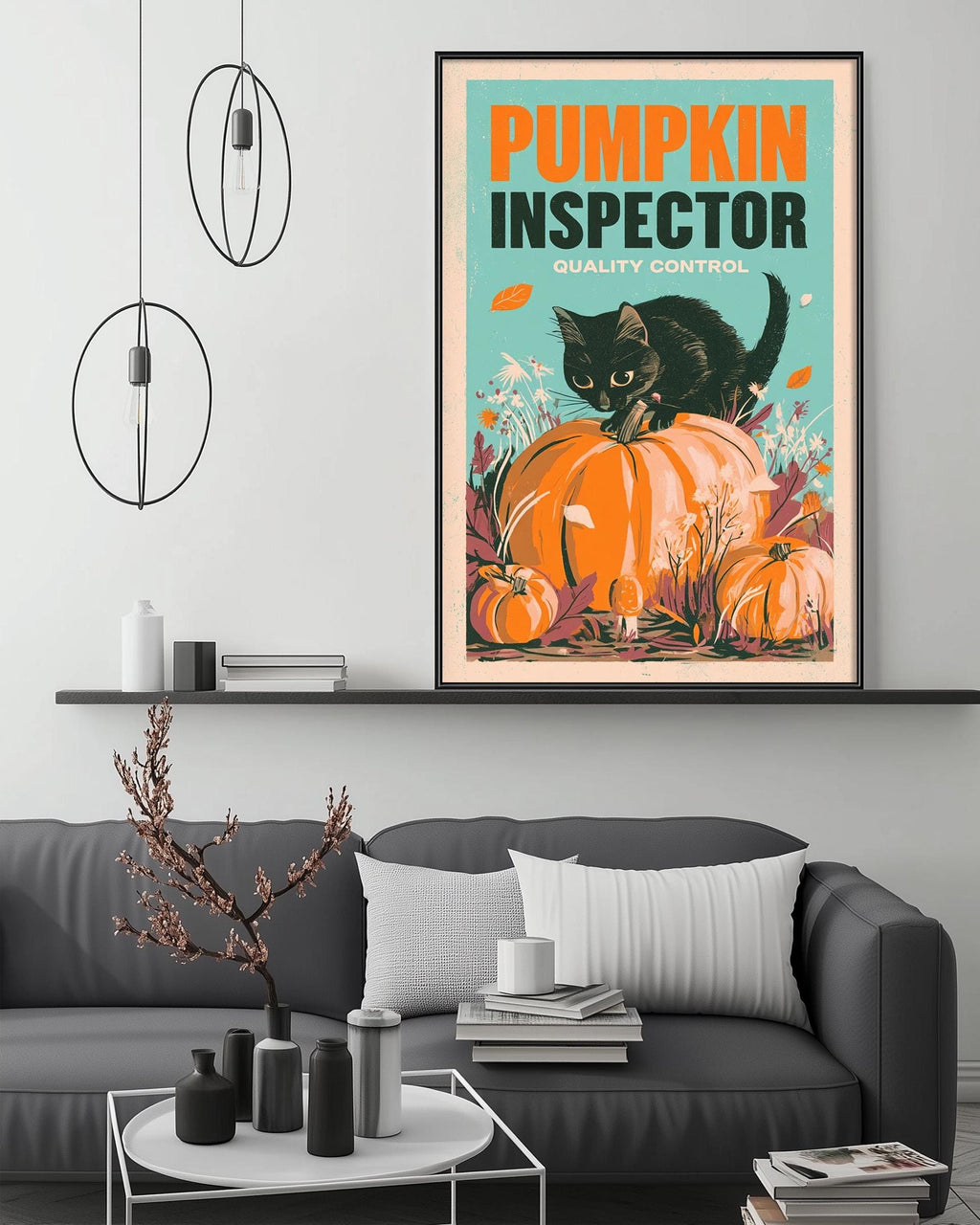 a poster of a black cat sitting on a pumpkin, with the text "Pumpkin Inspector Quality Control" displayed prominently. The poster is hanging on a wall above a gray couch, which has a coffee table in front of it. The room also contains a shelf with various decorative items, and a potted plant is visible in the background.