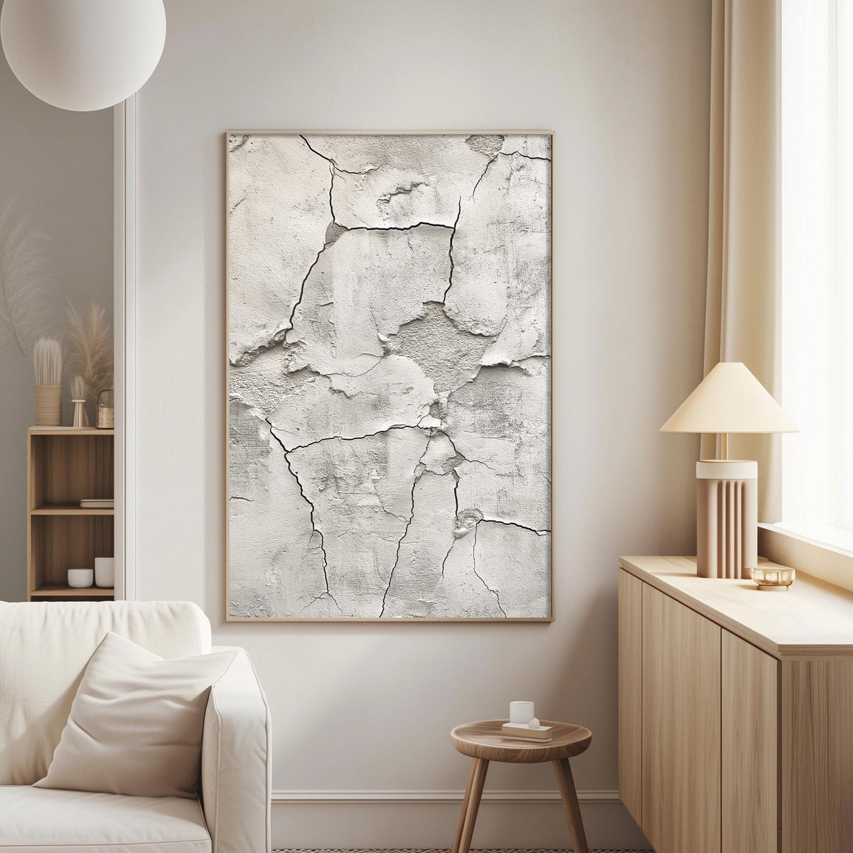 a living room with a large, textured wall art piece featuring a cracked, white surface. The room is furnished with a white sofa, a wooden side table, and a lamp on a wooden cabinet.
