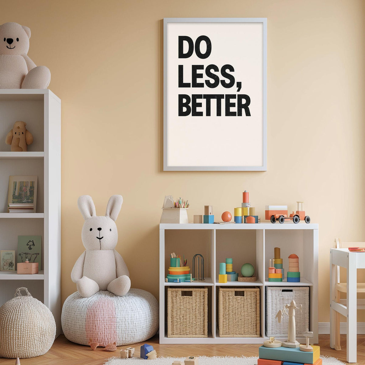 a child's playroom with a white bookshelf, a stuffed rabbit, a toy train, and a framed poster with the text "DO LESS, BETTER".