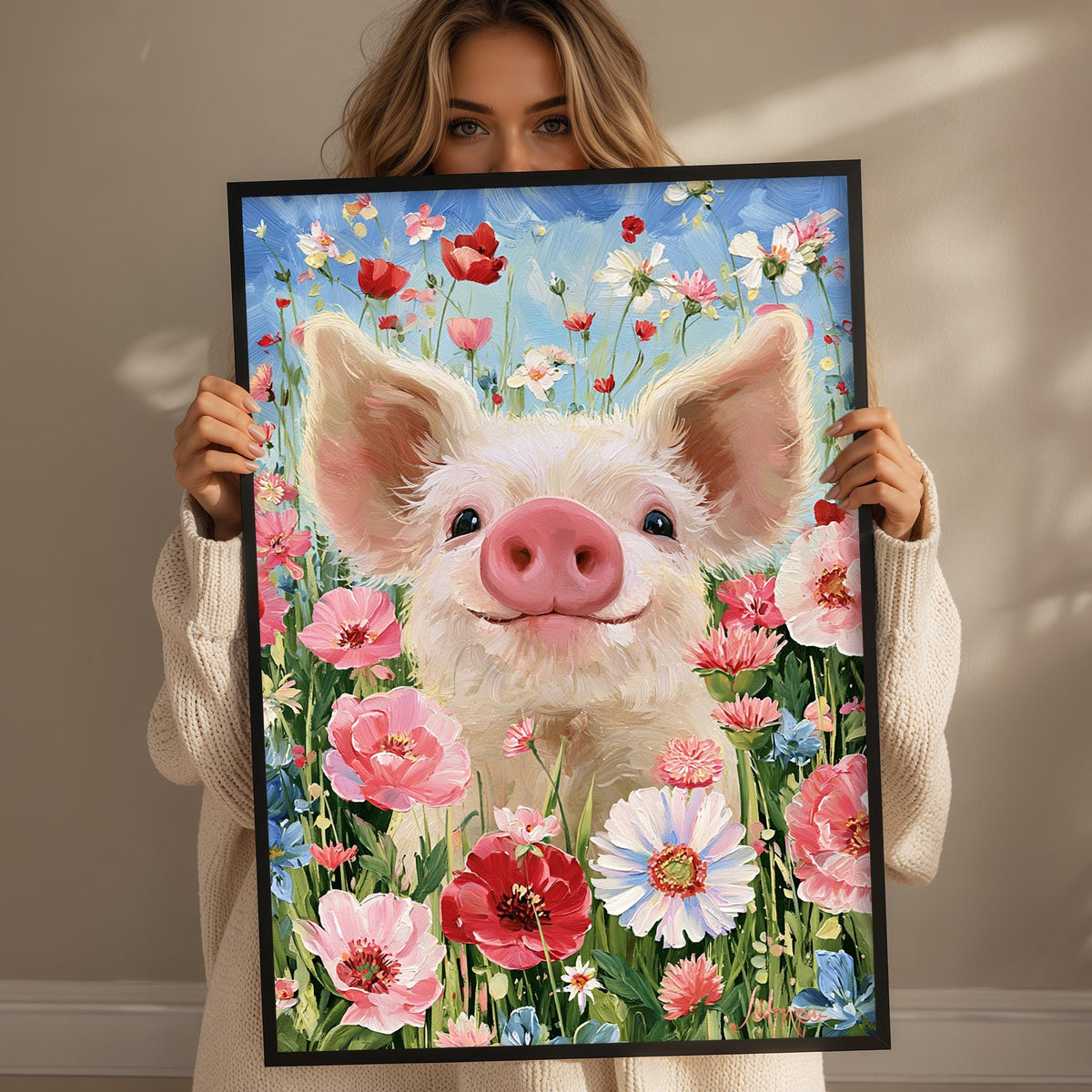 A woman holds up a framed painting of a smiling pig surrounded by a vibrant field of flowers.