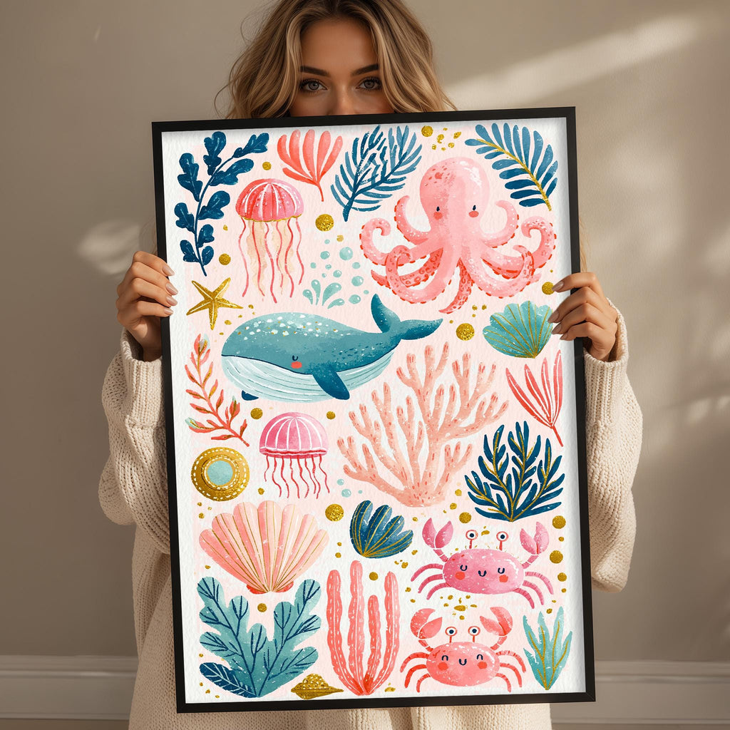 A woman is holding up a framed print featuring a vibrant underwater scene with various marine life, such as an octopus, jellyfish, whale, and coral.