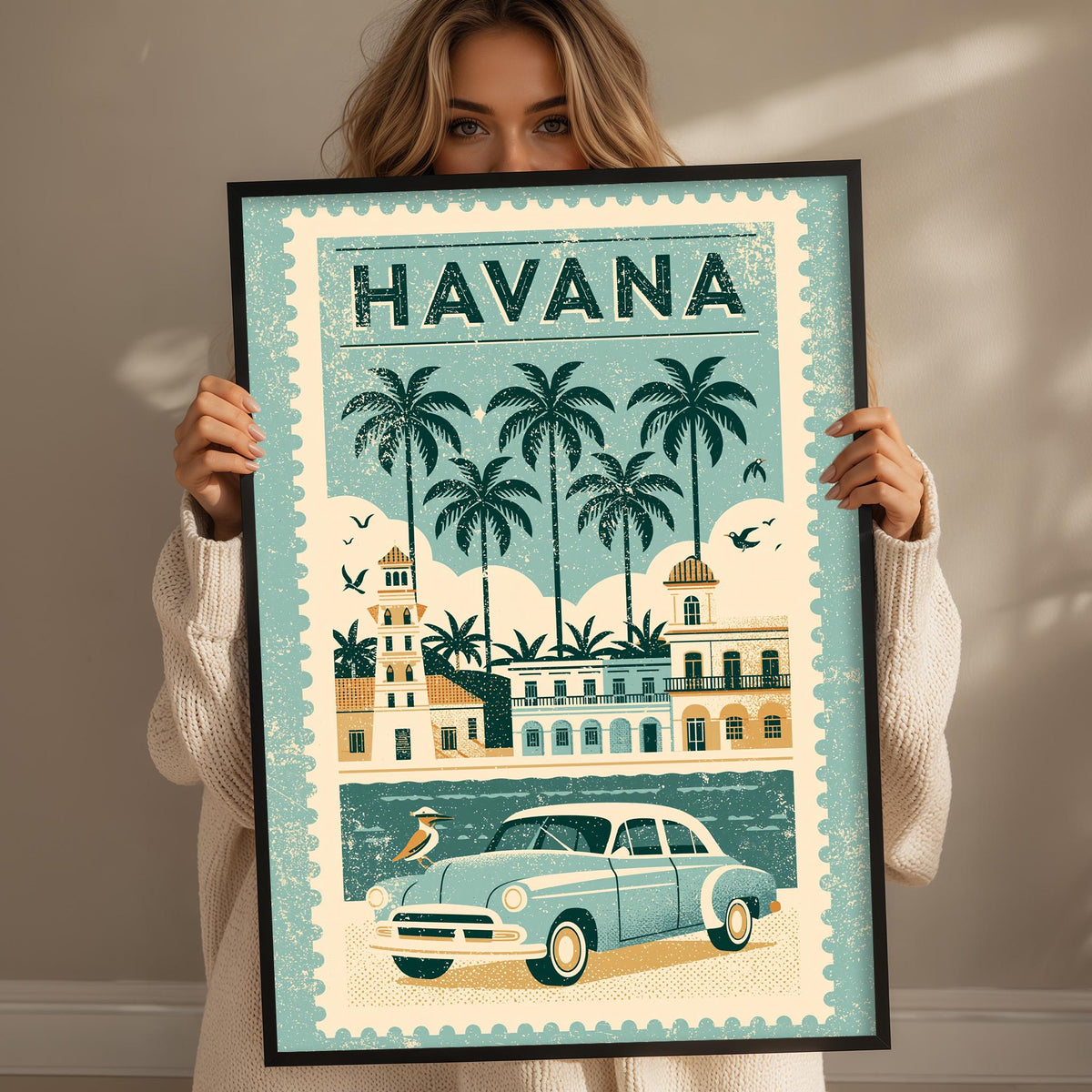 A woman holds up a framed poster of Havana, Cuba, featuring a vintage car and palm trees.