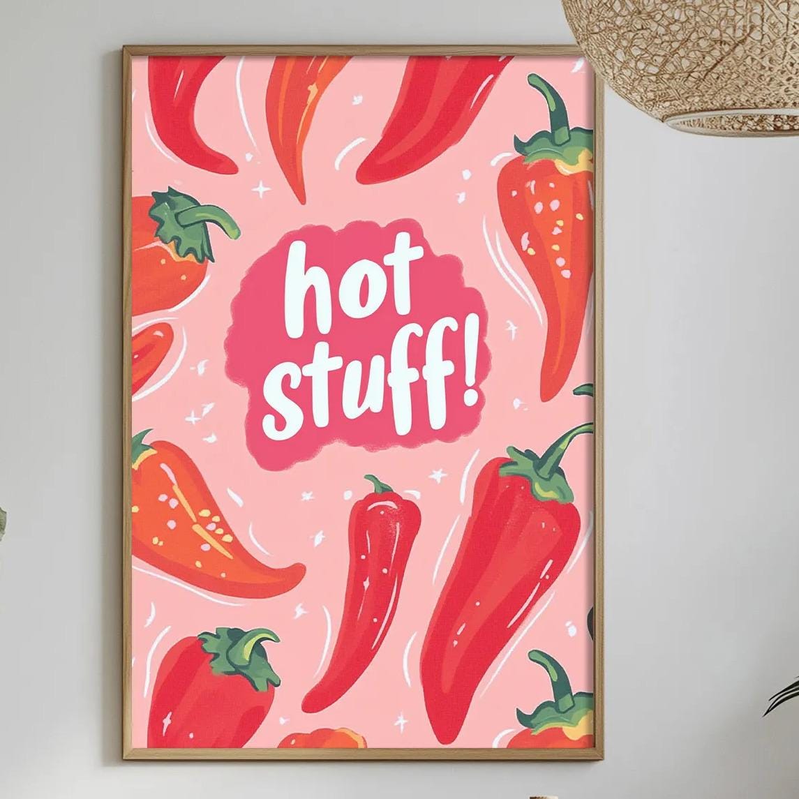 a dining table with a bowl of fruit, a bottle, and a vase of flowers, along with a framed poster with a red and pink design of peppers hanging on the wall.